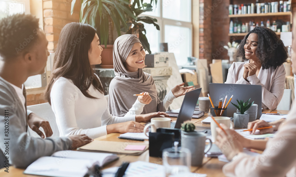 Diverse group of women working at a conference table